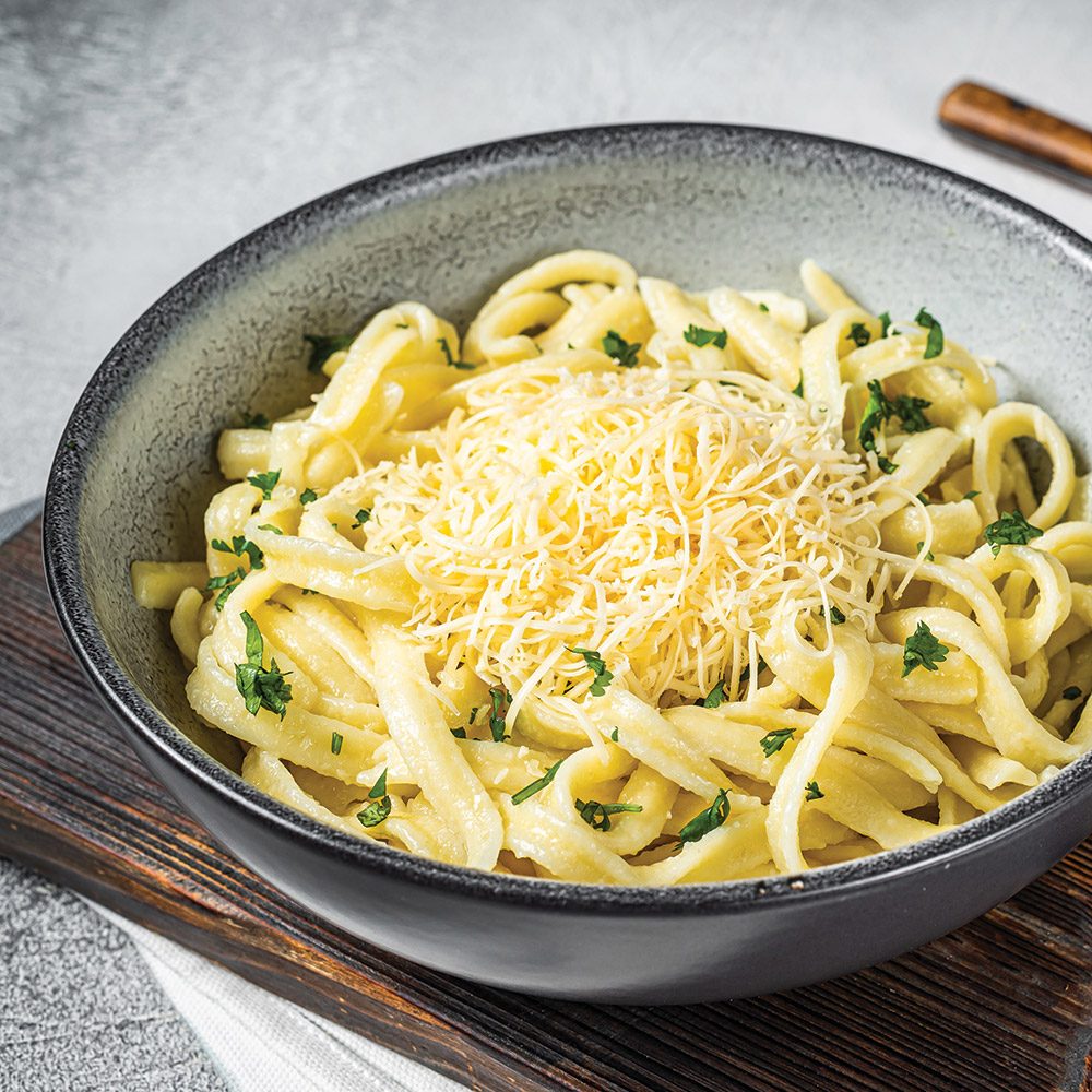 Bowl of pasta noodles with shredded parmesan